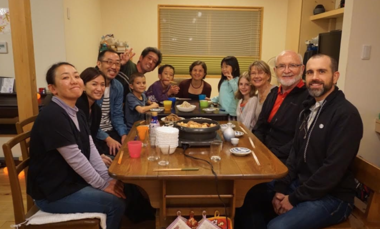 Two familys having dinner together after meeting each other for the first time.