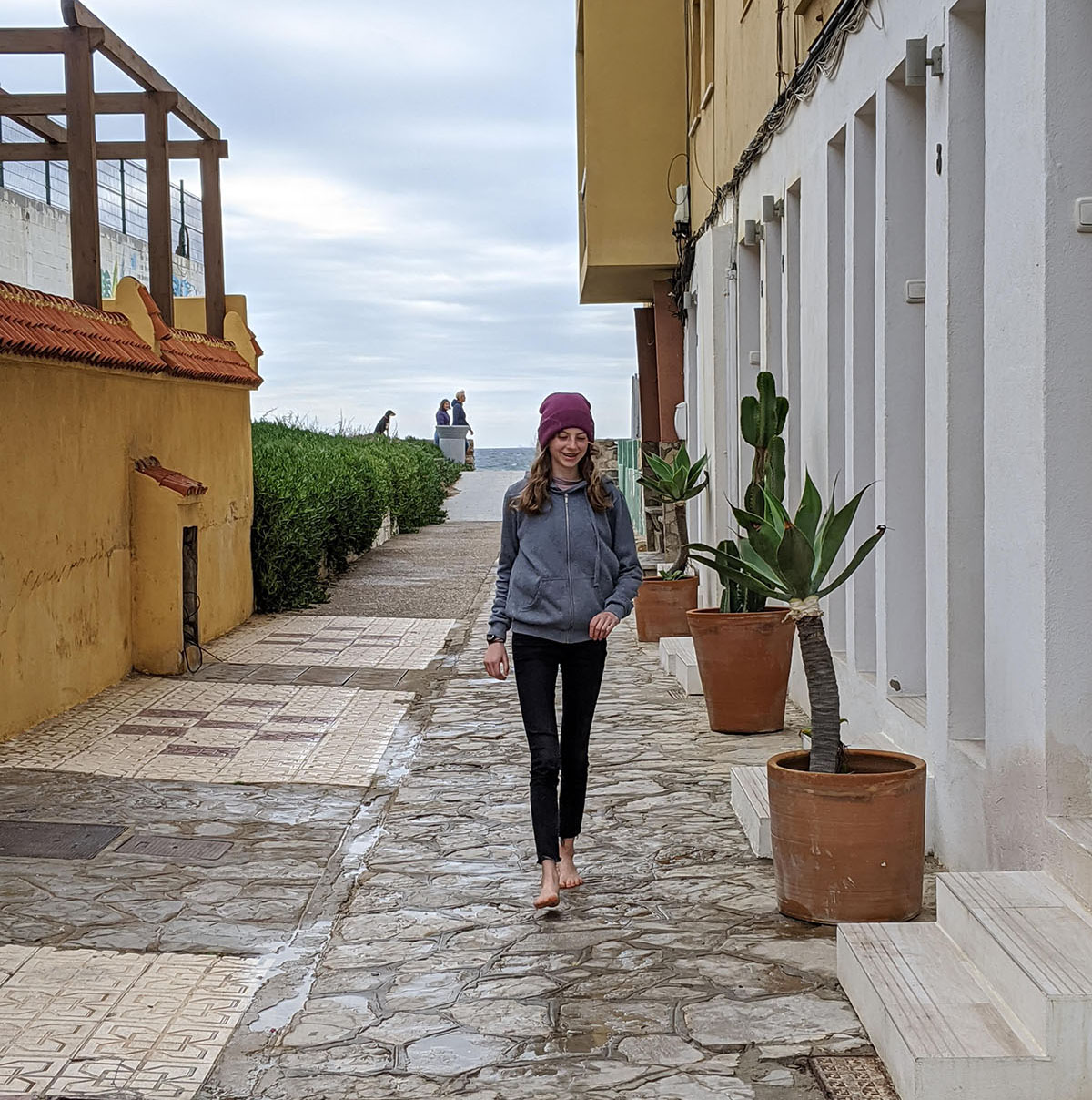 Person walking with ocean in background